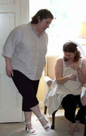 Jen proving she is actually wearing heels, while Tess looks down in disbelief